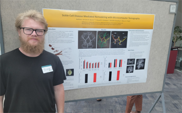 Jarrod Burns poses in front of a research poster