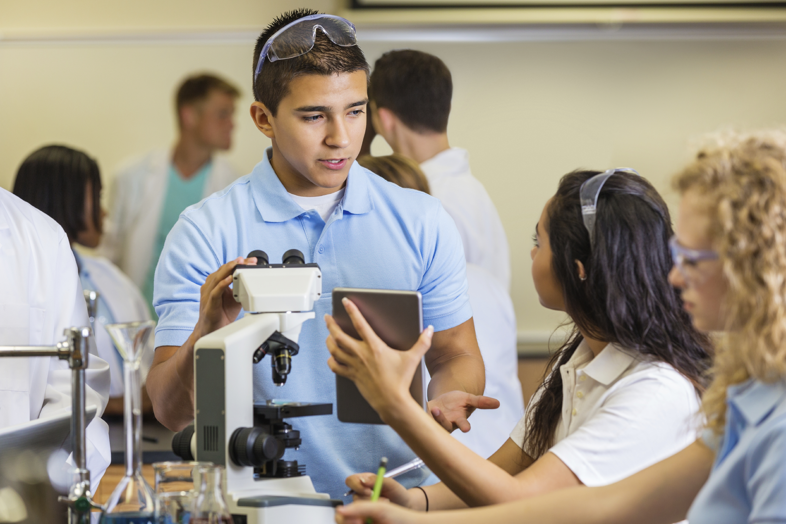Image of students in a classroom with a microscope