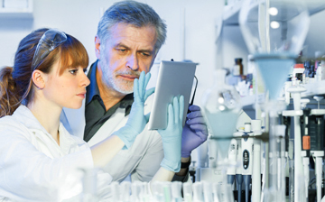 womand and man in lab looking at tablet