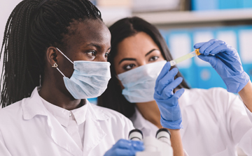 two women researchers with face masks in a lab