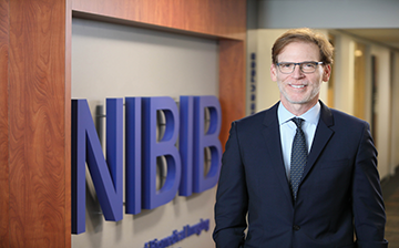Bruce Tromberg standing by NIBIB sign
