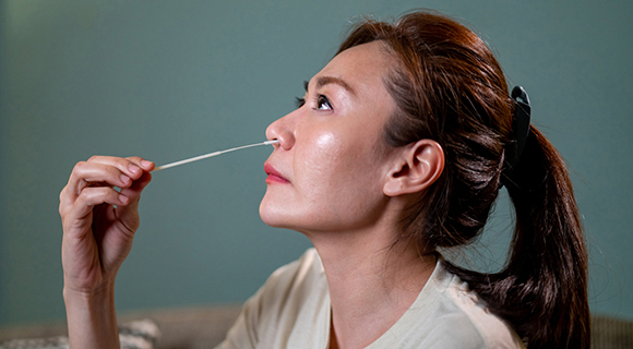 side view of women using nasal swab