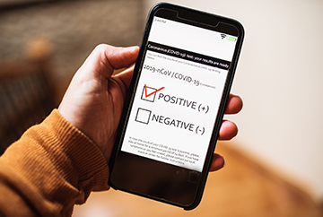 Person holding cell phone with test result box checked