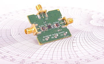 Radio frequency mixer printed circuit board PCB in front of Smith chart for microwave and RF calculations