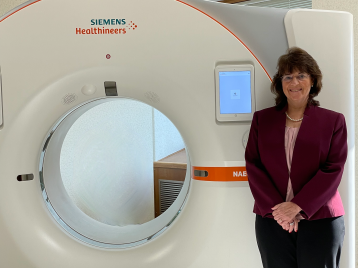 photo of Cynthia McCollough standing next a CT machine