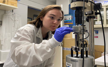 Olivia Ernst places a sample on an atomic force microscope.