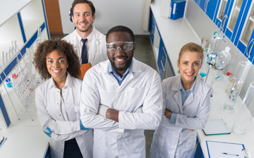 Four scientists in a lab looking at the camera