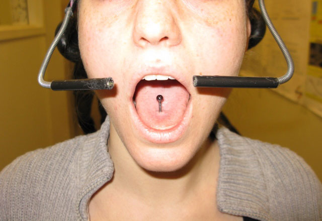 An individual with magnetic tongue piercing wearing the Tongue Drive System headset.