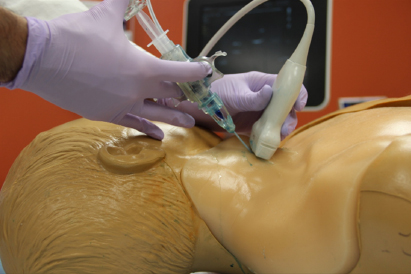 A photo of the device being demonstrated on a plastic model patient