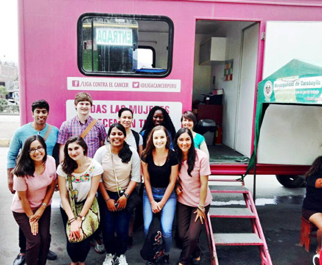 students standing in front of pink van
