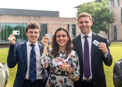 Woman with two young men holding a prototype of a device