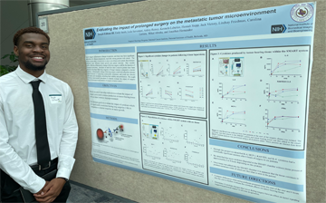 Joseph Editone III poses in front of a research poster