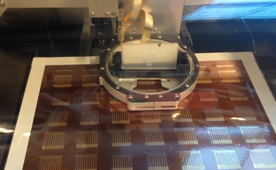 Inkjet printer layers gold nanoparticle ink in a pattern to construct a batch of biosensors.