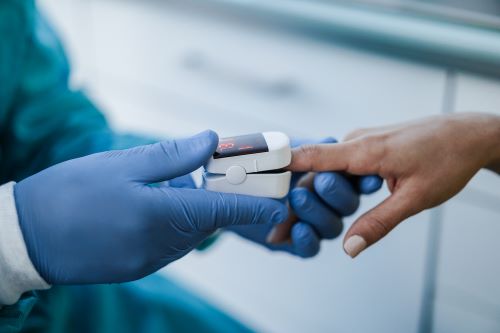 Clinician applying a pulse oximeter to a patient with dark skin