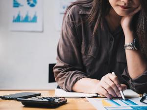 person looking at document holding a pen