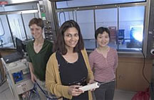 La Dra. Nirmala Ramanujam (con una aguja de biopsia en sus manos, al centro) y las estudiantes de posgrado Carmalyn Lubawy (izquierda) y Changfang Zhu han desarrollado una sonda óptica para ayudar a los médicos a tomar biopsias del seno con más certeza. La sonda se coloca dentro de la aguja de biopsia que los médicos usan actualmente. Foto por David Nevala.