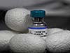 Photo of a vaccine vial nestled in a pile of silk cacoons