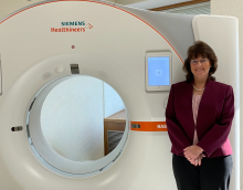 photo of Cynthia McCollough standing next a CT machine