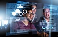 three people looking at a transparent computer screen