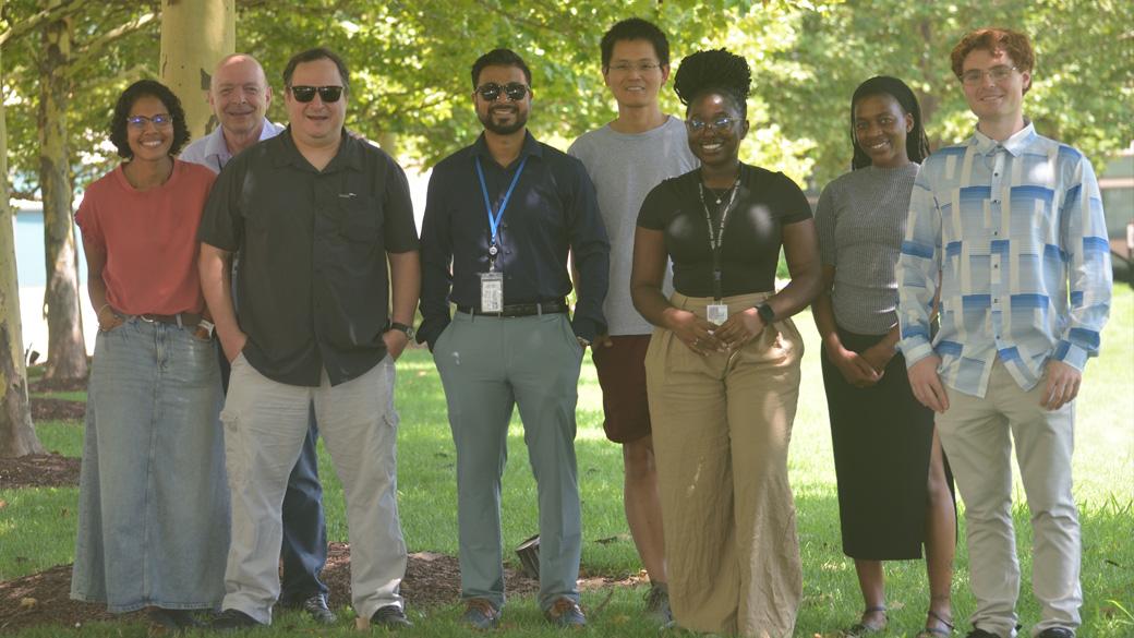 Group photo of people standing under trees