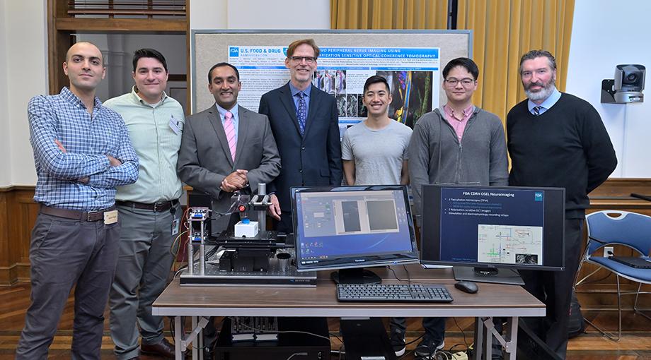 A team of researchers from the FDA and Massachusetts General Hospital with NIBIB Director Bruce Tromberg showcased an optical imaging device that can be used to take images of nerves just below the surface of the skin. Pictured from L-R: Mohsen Erfanzadeh, Guillermo Monroy, Srikanth Vasudevan, Bruce Tromberg, Kasey Kwong , Michael Tao, and Daniel Hammer.