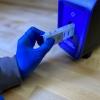gloved hand placing cartridge into blue instrument