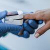Clinician applying a pulse oximeter to a patient with dark skin